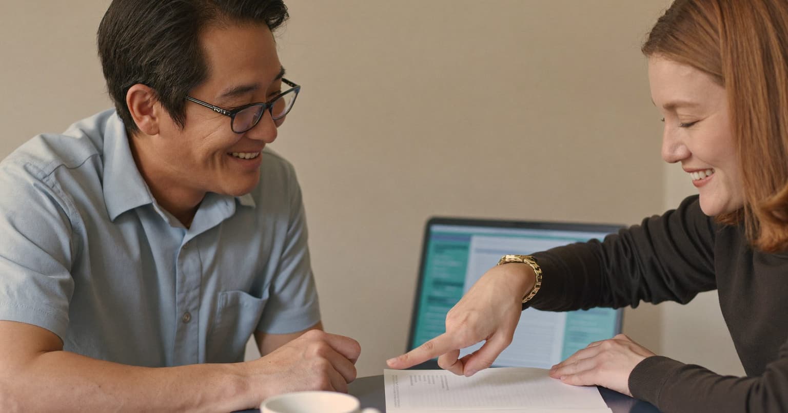Bookkeeper and freelance vendor comparing two printed forms at a café table