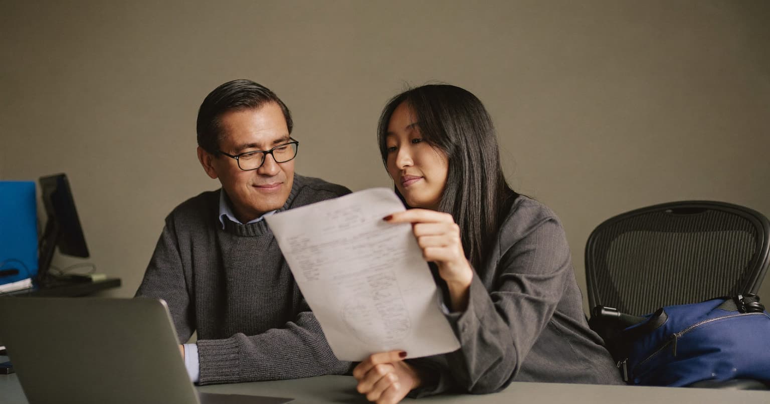 Bookkeeper and freelance photographer reviewing the top lines of a paper form together